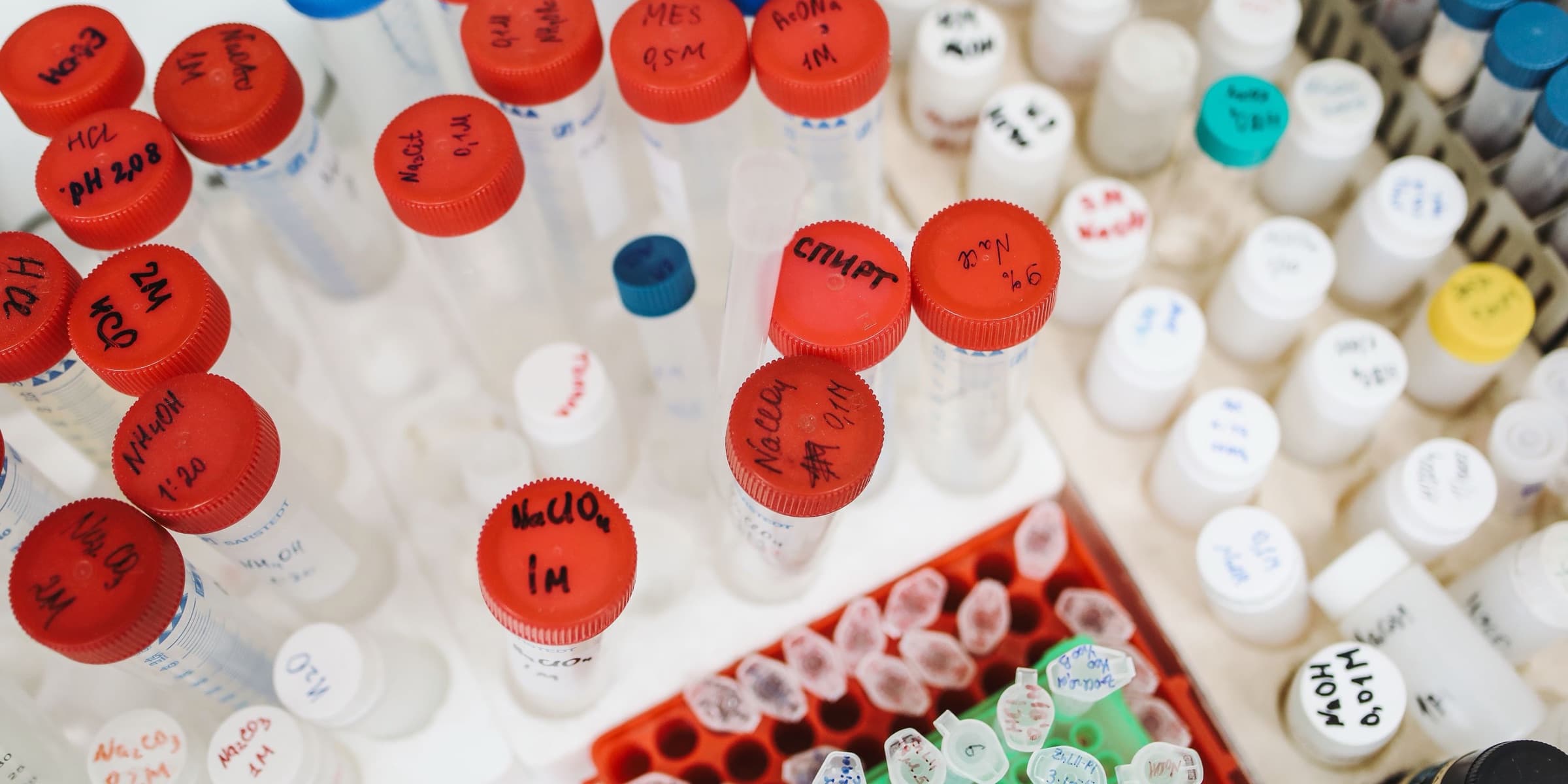 Test tubes and bottles with coloured caps from above